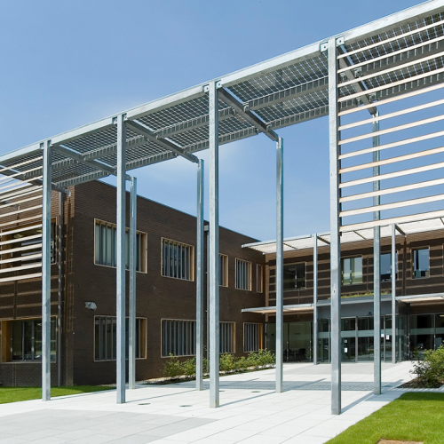 The modern and architectural Hoddesdon head office building shot against a blue sky background and green grass.