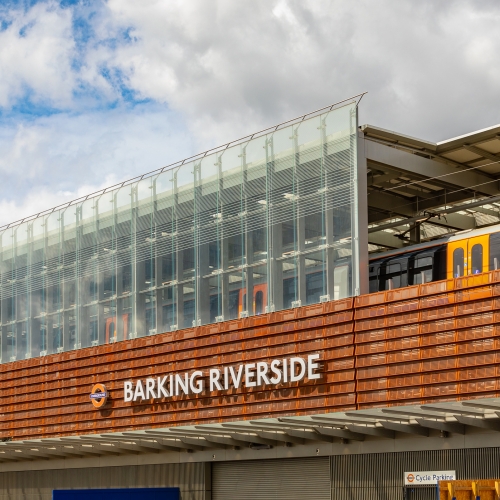 Barking Riverside station train pulls in against blue sky