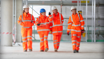 Female construction workers wearing orange high vis on site