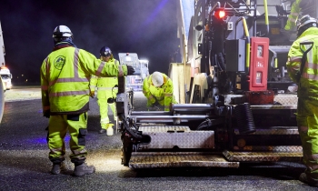 Heathrow airport resurfacing shot at night. Workers in yellow PPE