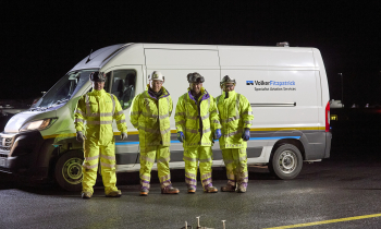Heathrow airport resurfacing shot at night. Workers in yellow PPE